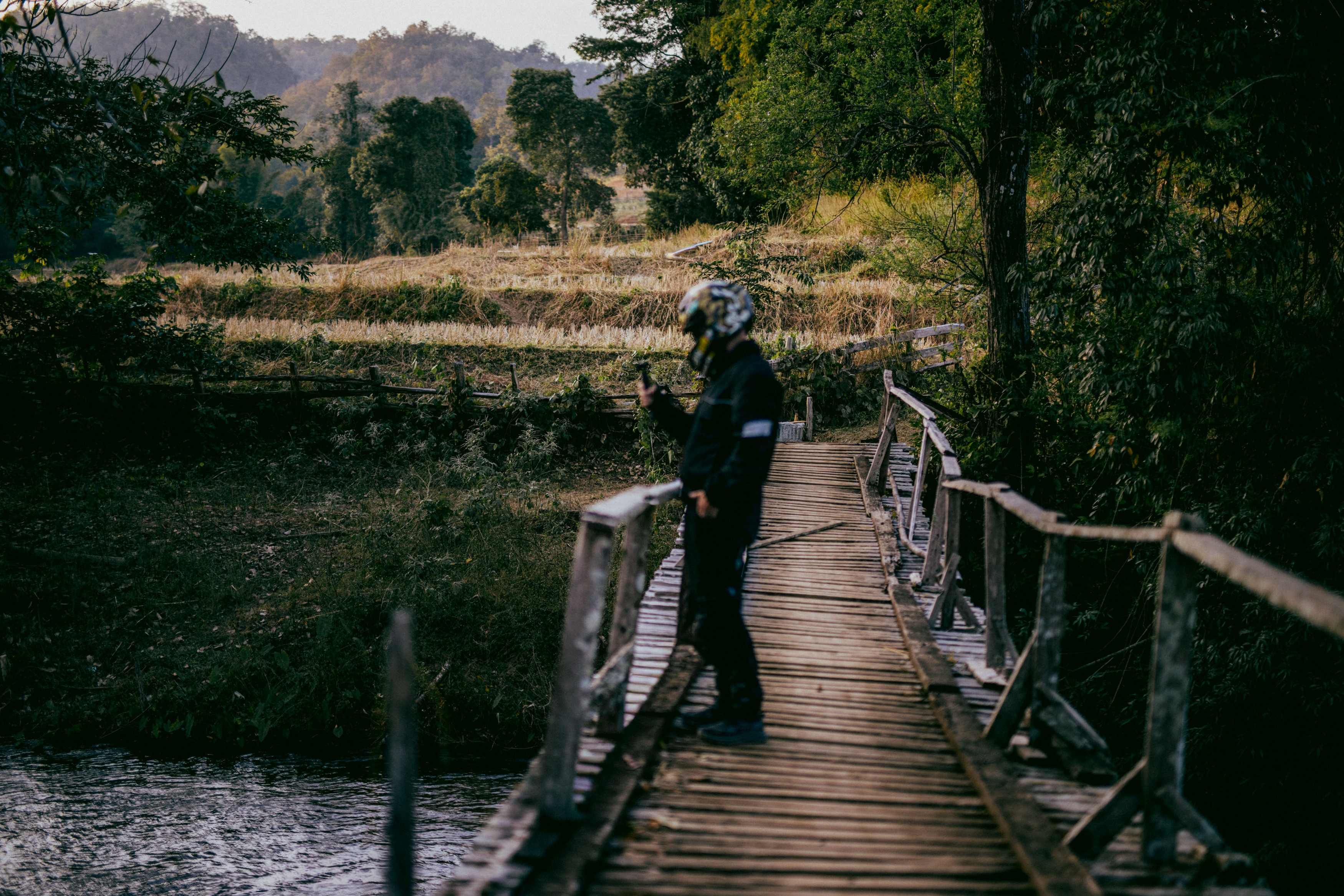 A rider standing on a wooden bridge