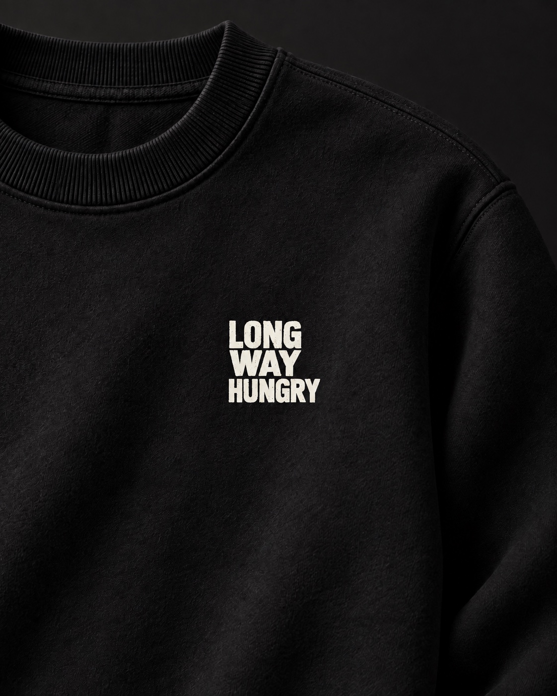Close detail of the black sweatshirt collar, heavyweight fabric and white Long Way Hungry chest logo